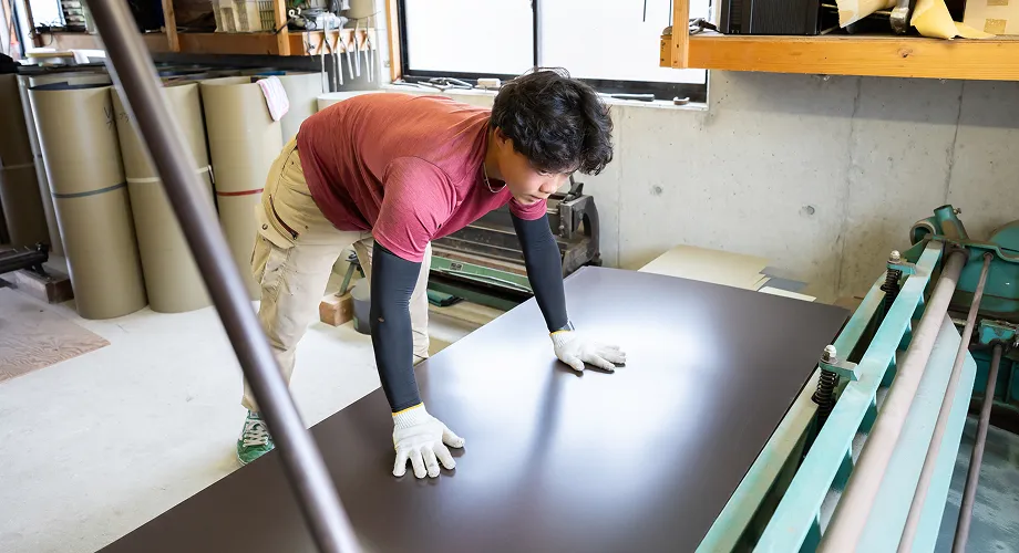 屋根材の加工作業をする職人