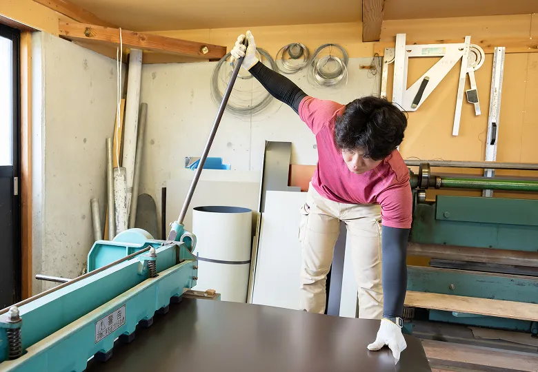屋根材の加工作業をする職人