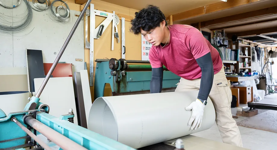 屋根板金の加工作業をする職人