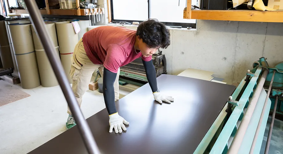 屋根材の加工作業をする職人