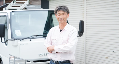 社用車の前に立つ土屋板金のスタッフ